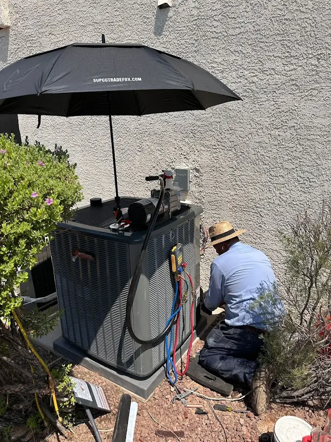 HVAC technician performing outdoor AC maintenance in Lakewood