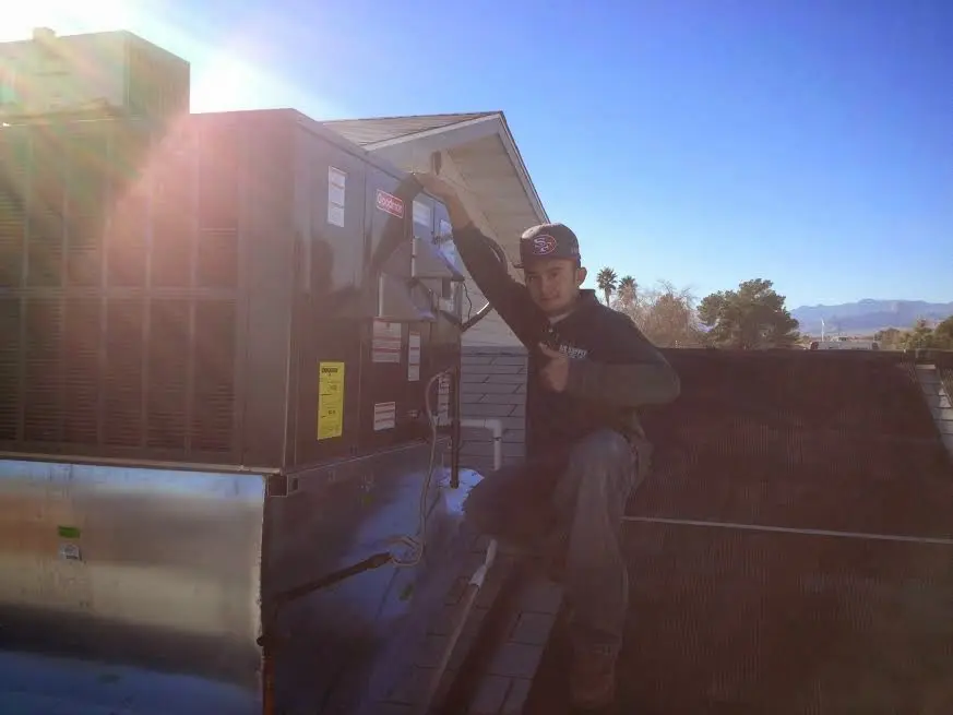 HVAC technician performing HVAC Inspection on a rooftop unit in Lakewood